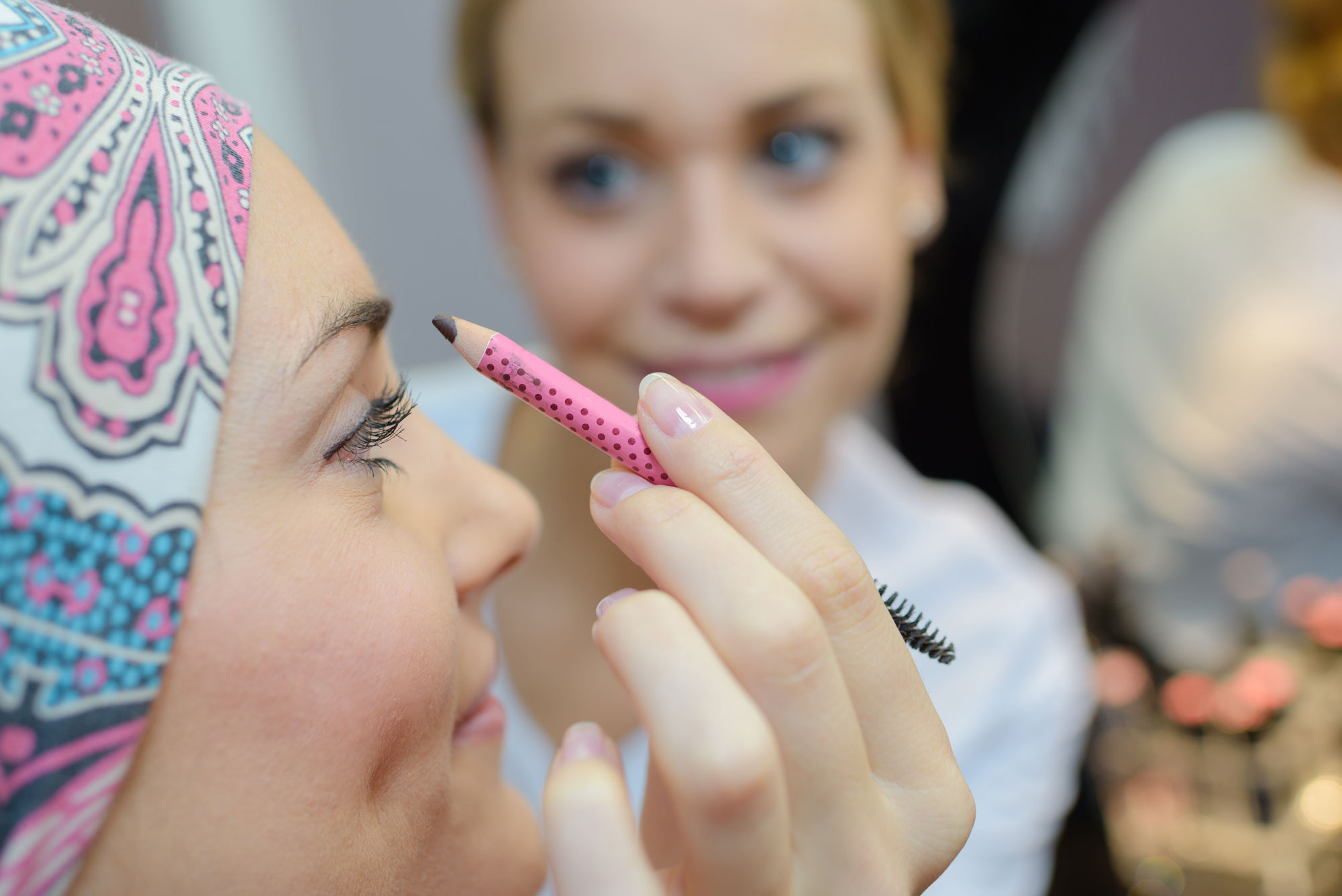 femme avec bandeau sur la tête se fait maquiller